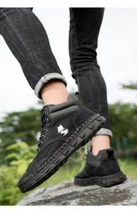 Detailopname van zwarte PU-leren laarzen met witte stiksels en getextureerde afwerking