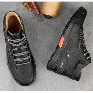 Macro-opname van zwarte hoge schoenen met oranje accenten en handgemaakte contraststiksels