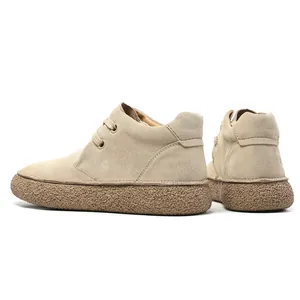 Detail of matte suede texture and thick textured rubber sole on khaki mid-top boots