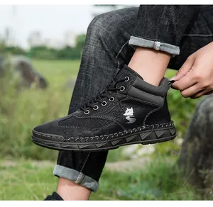 Detail van zwarte heren enkellaarzen van leer met handstiksels en een wolf-logo