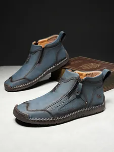 Nahaufnahme von blauen Herren-Stiefeletten aus mattem Leder mit handgenähten Gummisohlen