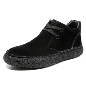 Detailed macro view of black suede desert boots with white contrast stitching and durable thick sole