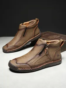Detailansicht brauner Lederstiefel mit Reißverschluss und rustikaler handgefertigter Naht