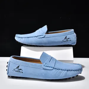 Dettaglio di mocassini in pelle scamosciata azzurra con suola a gommini e logo Salkin