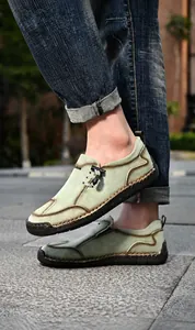Detailweergave van groene suède loafers met contrasterende stiksels en rubberen zool
