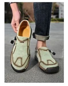Detail van mintgroene leren loafers met handgestikte naden en sportieve rubberen zool