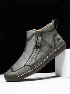 Makroansicht der grünen Vintage-Lederstiefel mit Handnähten und seitlichem Reißverschluss