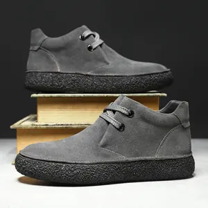 Men's grey suede mid-top chukka boots with thick black soles and lace-up design