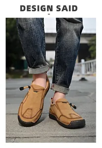 Detail van handgemaakte herenloafers van camel suède met sportlabel en vetersluiting