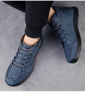 Detail van blauwe suède herenboots met grijze veters en robuuste stiksels op de schoen