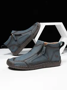 Details von blauen Wildleder-Boots mit seitlichem Reißverschluss und Handnaht