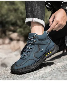 Detalle de botas de exterior azul marino con costuras de contraste y suelas de goma
