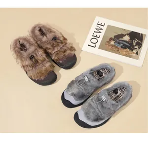 Dettaglio di scarpe in peluche marroni e grigie con morbida pelliccia e coulisse