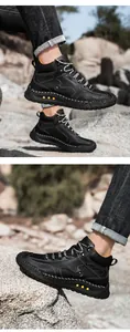 Detalle de botas de cuero negro con costuras en contraste y puntos amarillos en la suela