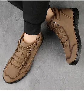 Detail van bruine outdoorlaarzen voor heren met stiksels en duurzame rubberen zolen