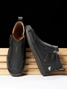 Detaillierte Makroaufnahme der schwarzen Herren-Lederstiefel mit Reißverschluss und Handnaht