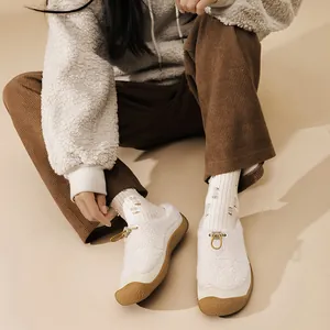 Vista dall'alto di scarpe slip-on in peluche beige da donna con pile e suola in gomma