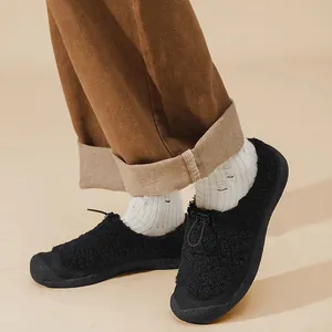 Dettaglio di scarpe slip-on in pile nero con cordino regolabile e calda fodera interna