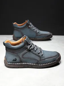Detailaufnahme der blauen Herrenlederboots mit Ziernähten und geprägtem Widder-Logo