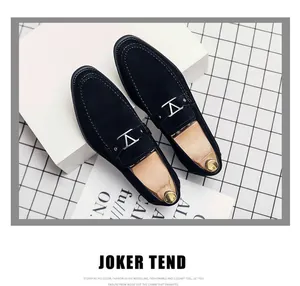Detalle de mocasines de ante para hombre con hebilla en V plateada y acabado negro