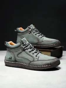 Detail der High-Top-Lederstiefel mit Handnaht und geprägtem Ziegenlogo an der Seite