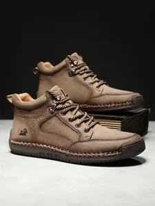 Detailansicht brauner Lederstiefel mit groben Nähten und geprägtem Schaf-Logo