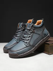 Detailansicht der hohen Lederstiefel mit Ziernähten und robuster Gummisohle für Herren