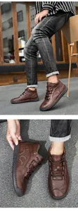 Detail of hand-stitched seams and logo on brown leather outdoor mid-top men's shoes