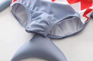 Dettaglio costume da bagno neonato squalo con pinna 3D e bordi elastici grigi