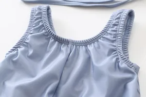Dettaglio delle spalline elasticizzate arricciate di un costume da bagno blu neonato