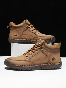 Detailansicht der braunen Leder-Herrenstiefel mit Ziernähten und geprägtem Logo