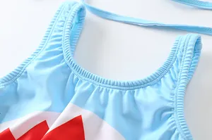 Dettaglio costume da bagno bimbo blu con motivi rossi e scollatura con volant