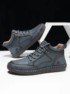Detailansicht der blauen Lederstiefel mit Handnähten und Ziegen-Logo-Akzenten