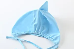 Dettaglio cuffia nuoto neonato azzurra con pinna di squalo e laccetti sotto mento