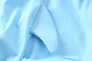 Dettaglio del tessuto del costume da bagno per neonati con pinna 3D in azzurro