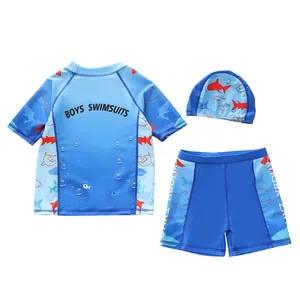 Driedelige zwemset voor jongens met blauwe haaienprint top, zwembroek en bijpassende muts