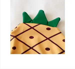 Detail van baby ananas zwemkleding met groene stoffen bladeren en geel textuurpatroon