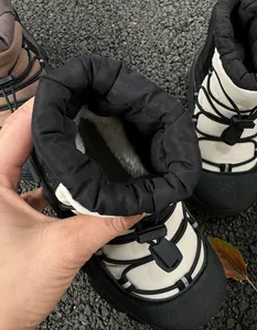 Close-up of kids waterproof snow boots with thick faux fur lining and drawstring toggles