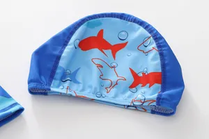 Detail van lichtblauwe kinderzwemmuts met haaienprint en donkerblauwe bies
