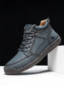Detailansicht der dunkelblauen Wildleder-Stiefel mit Ziernähten und geprägtem Logo