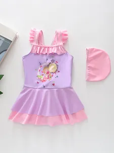 Detail view of girls mermaid swimsuit with pink ruffles and matching swim cap on white background