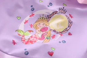 Detail view of purple fabric with cartoon mermaid and seahorse print on kids swimwear