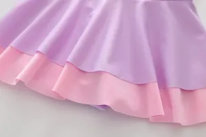 Macro view of double-layered lavender and pink ruffles on girls' swimsuit fabric