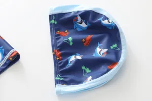 Detail van kinderzwemmuts met haaien- en palmboomprints op blauwe elastische stof