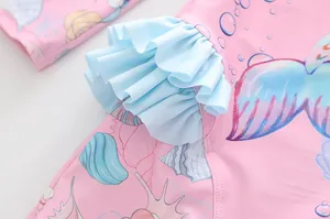 Detail von blauen Rüschen und Meerjungfrau-Prints auf dem rosa Kinderbadeanzug