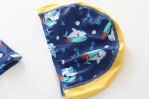 Detail van kinderzwemmuts in marineblauw met haaienprint en gele afwerkrand