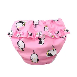Detail einer rosa Kleinkind-Schwimmwindel mit Pinguin-Prints und Rüschen an der Taille