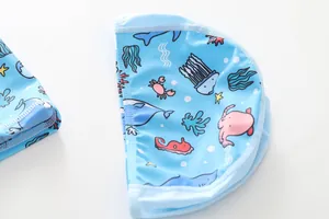 Detail van lichtblauwe kinderzwemmuts met kleurrijke cartoon zeedieren patronen