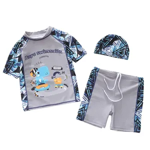 Détail du maillot de bain 3 pièces pour enfants avec motif dinosaure et imprimé géométrique bleu