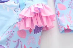 Detail der rosa Rüschen am langärmeligen Mädchen-Badeanzug mit Meeresmotiven